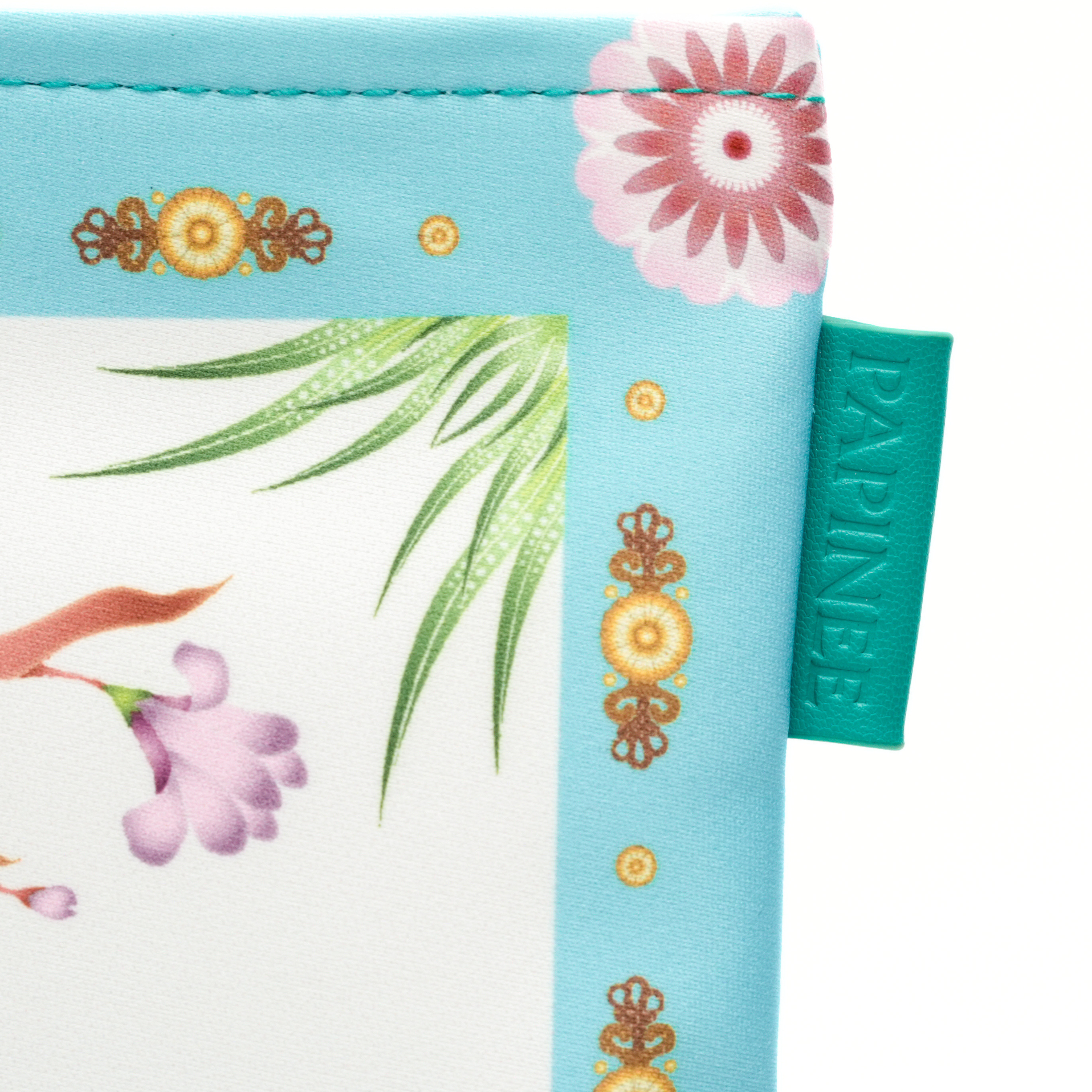 Close-up of a decorative product with floral and leaf patterns on a blue background, featuring the brand 'Papinee'.
