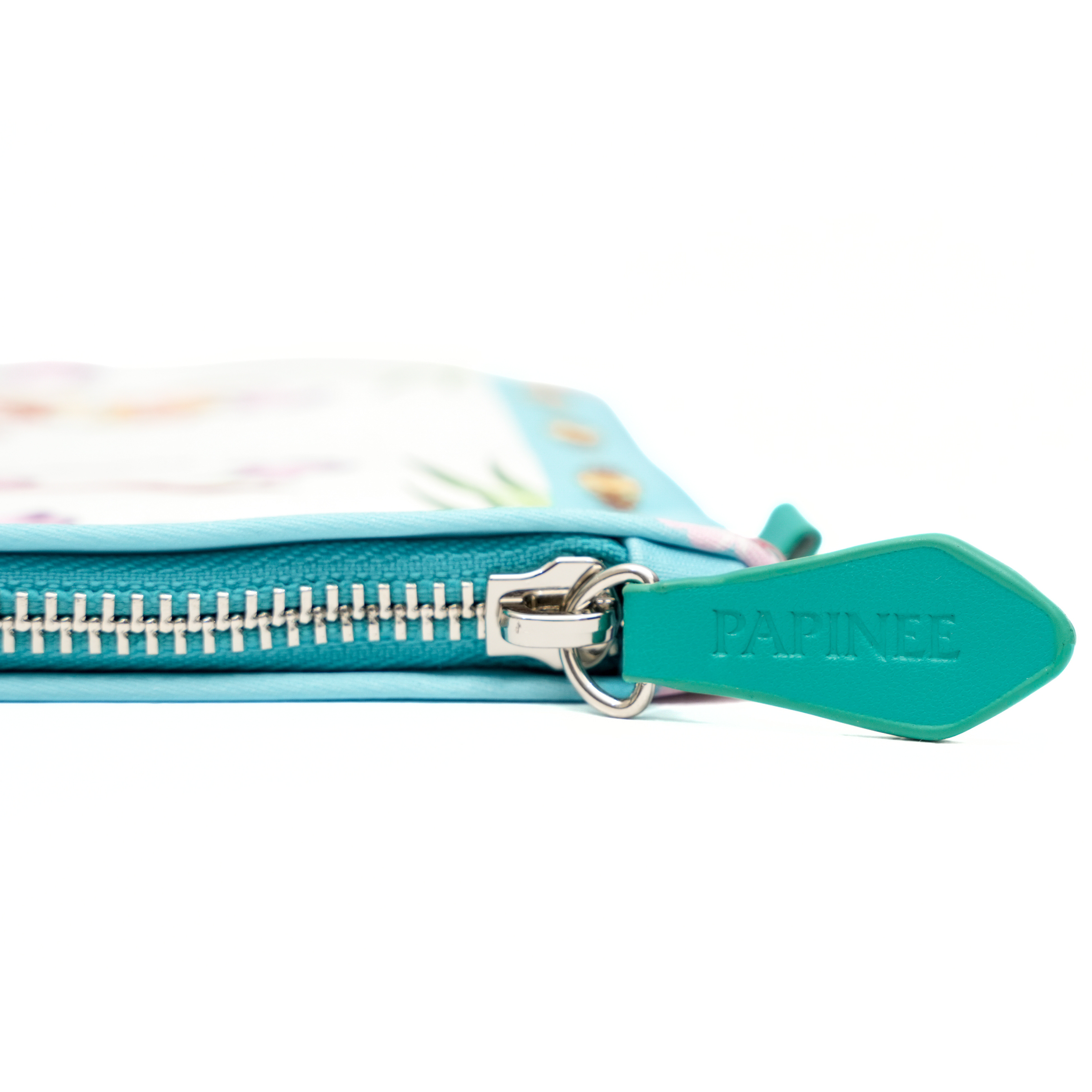 Close-up of a teal pouch with a zipper and 'PAPINEE' branding on a white background.
