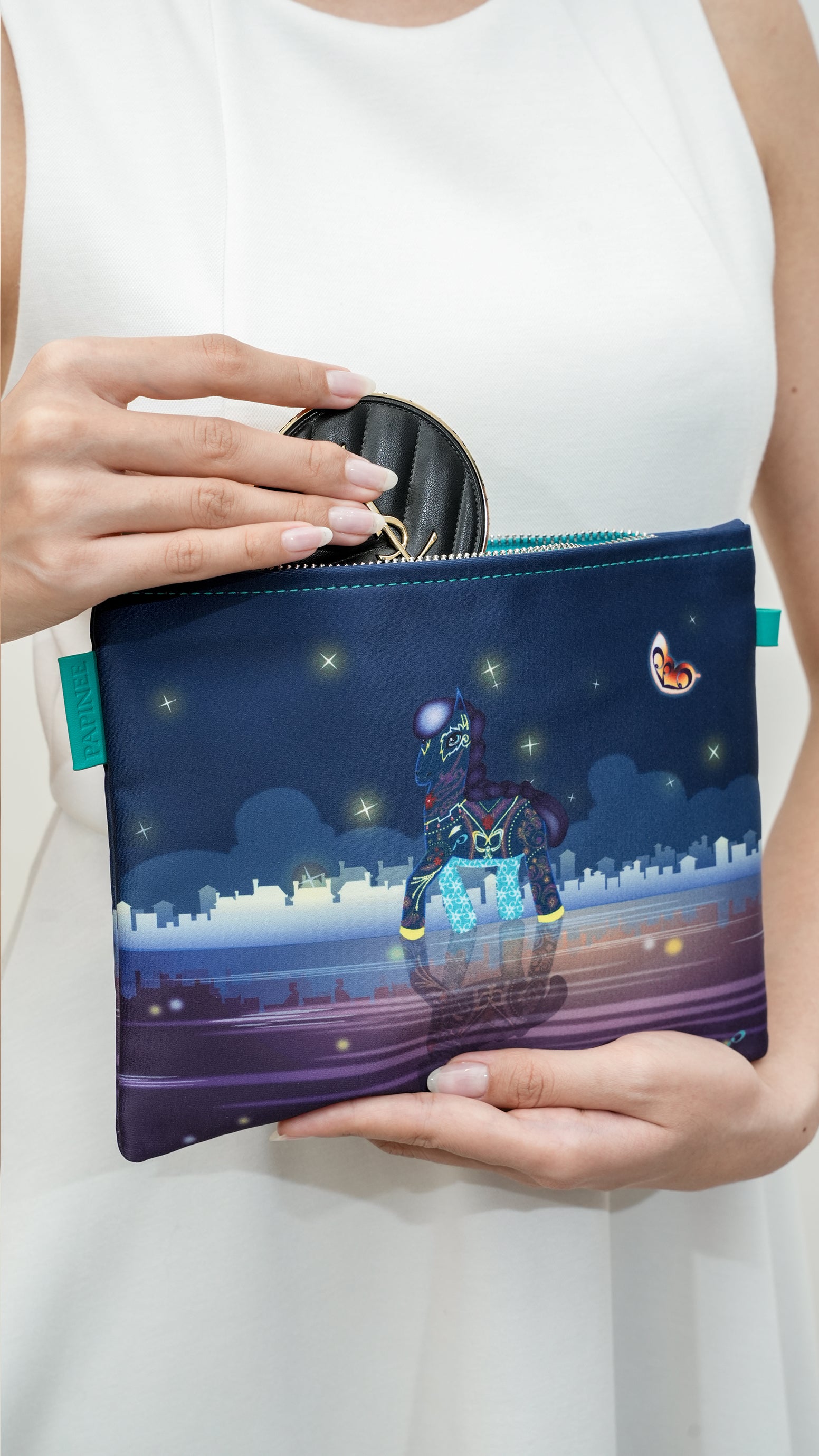 Person holding a pouch with a horse design on a cityscape background