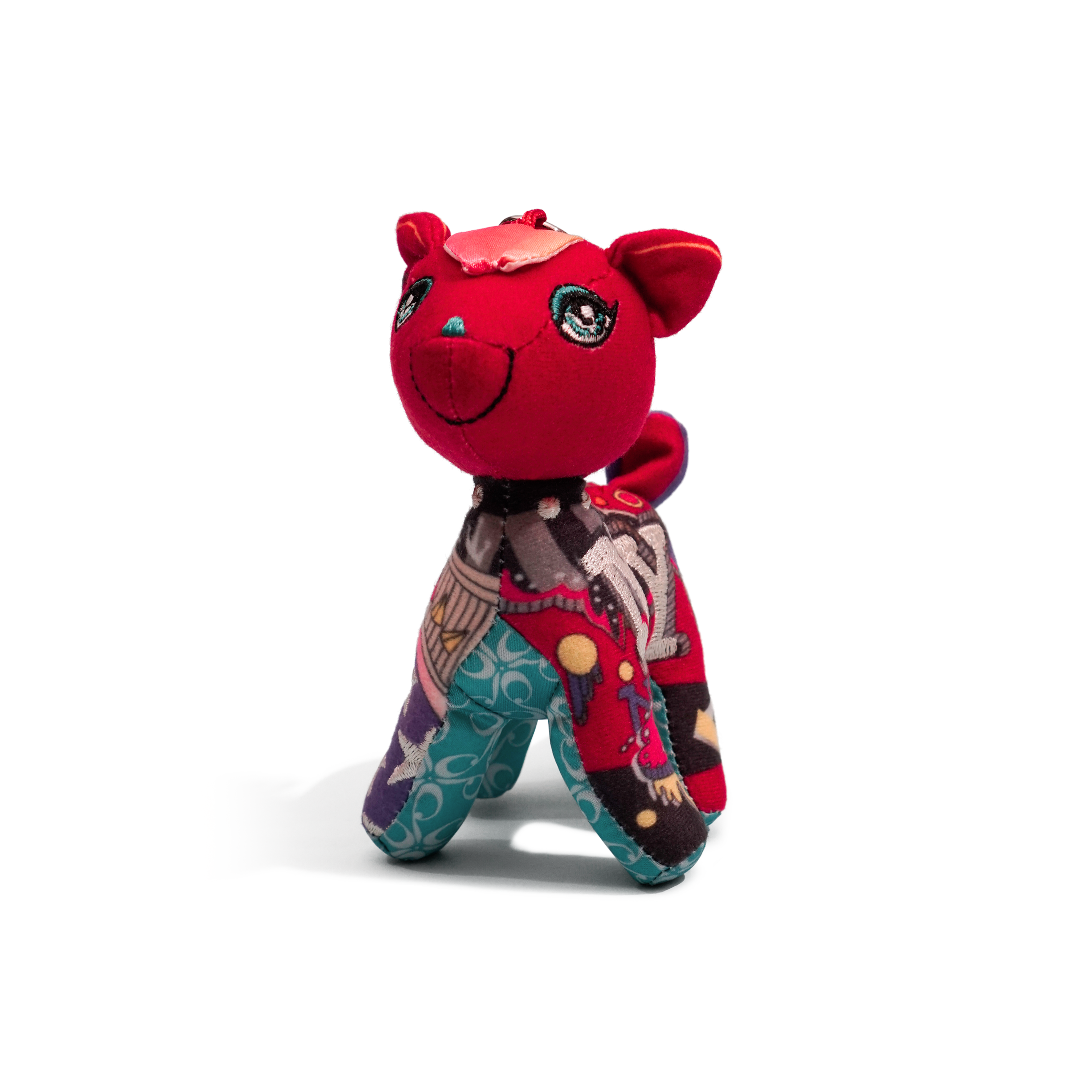Red plush toy with a patterned outfit on a white background