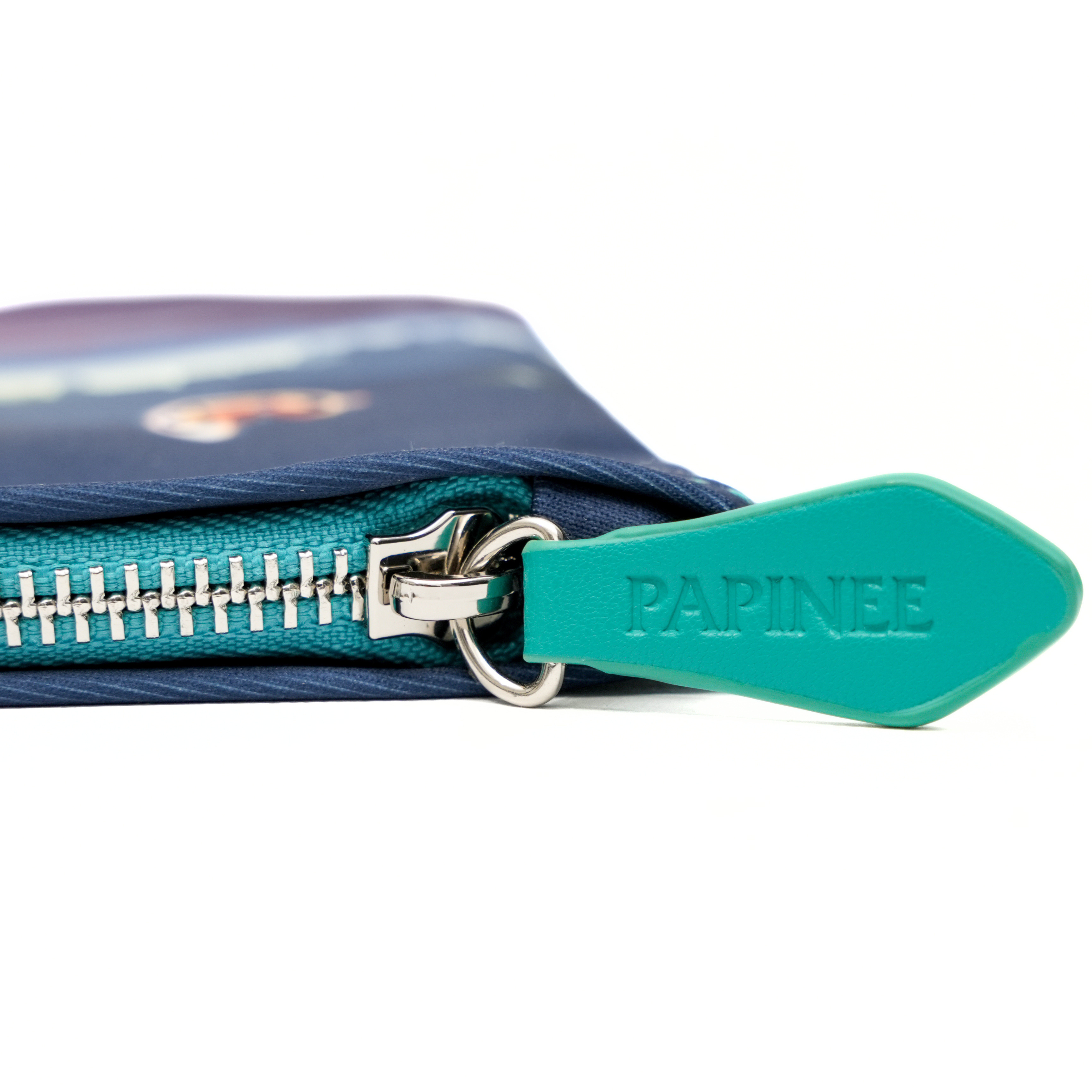 Close-up of a blue pouch with a teal zipper and 'PAPINEE' branding on a white background.