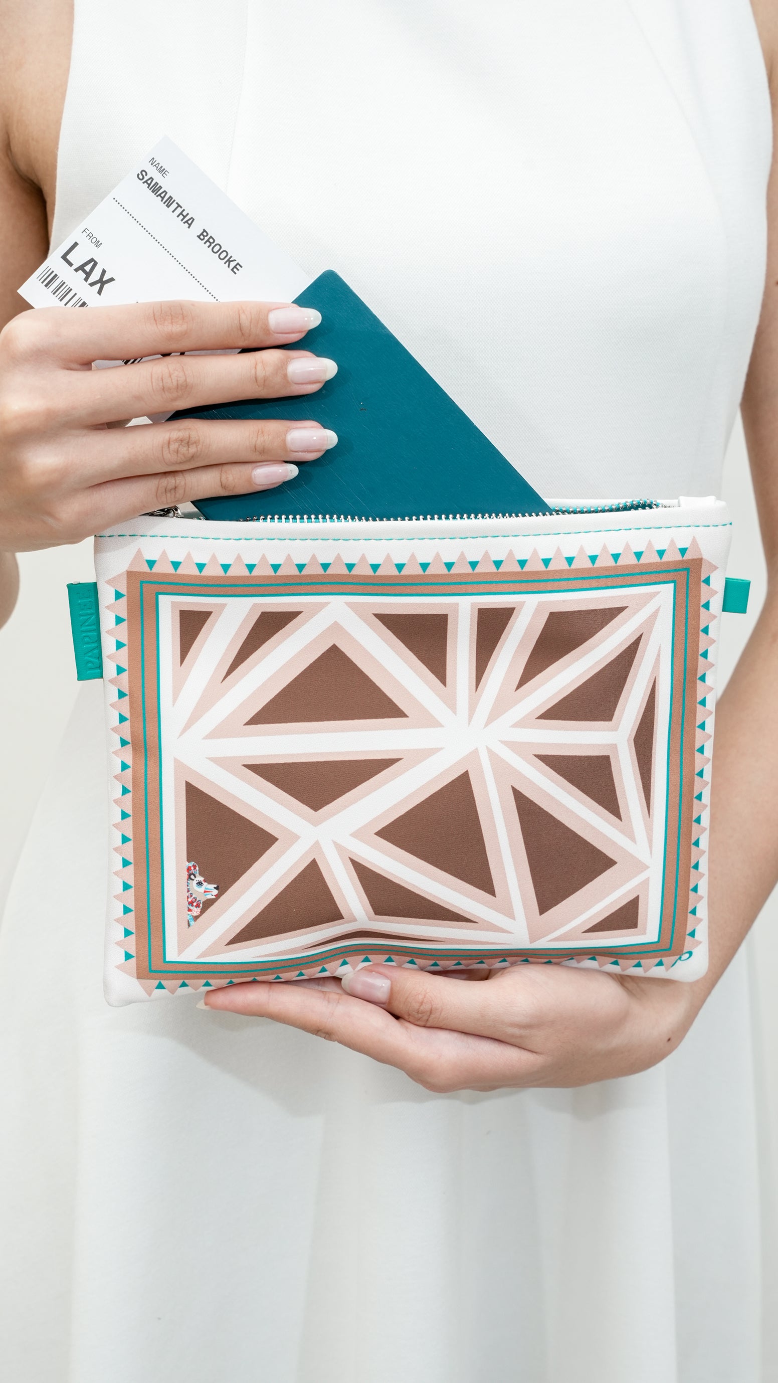 Person holding a patterned pouch with a geometric design