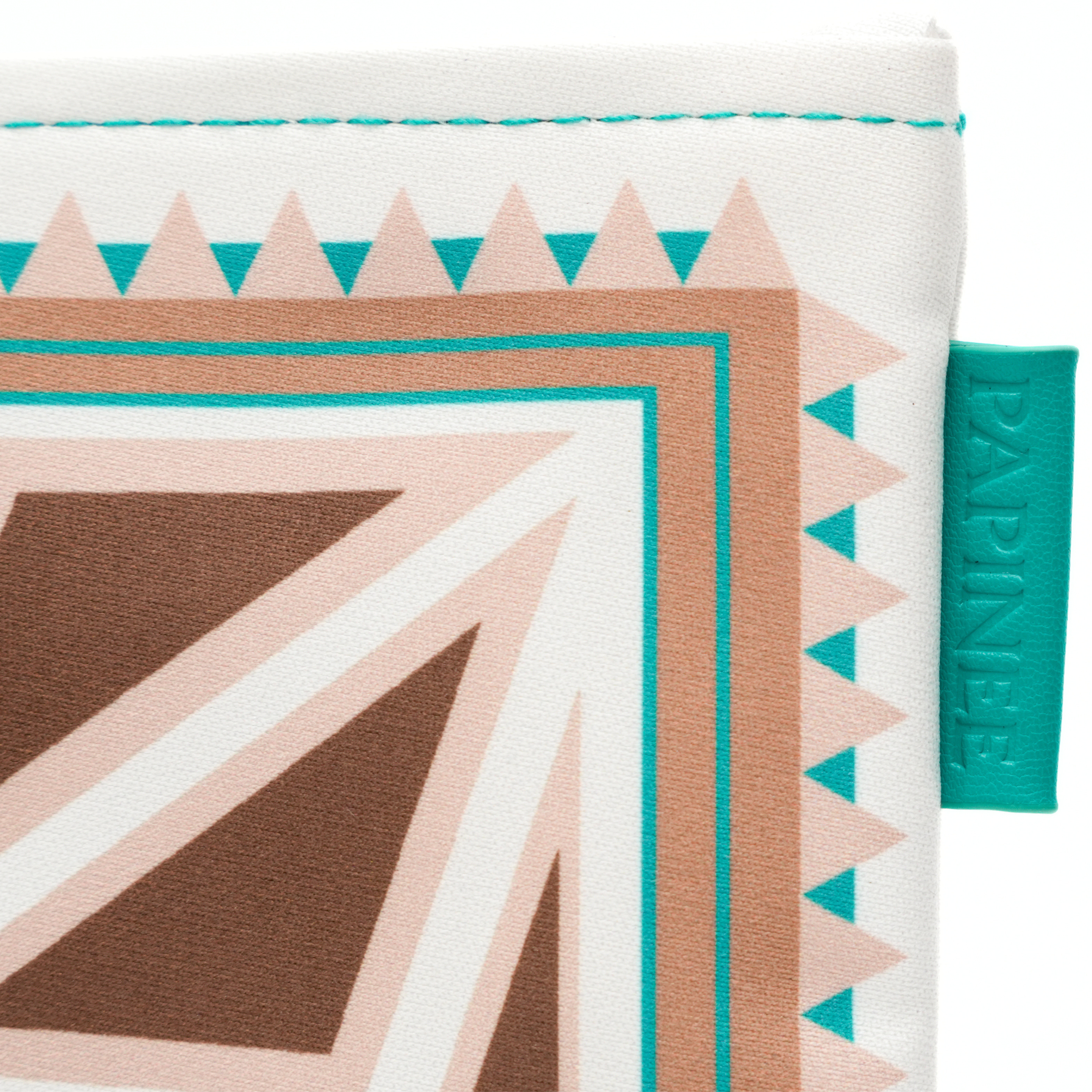 Close-up of a fabric with geometric pattern and a brand tag on a white background