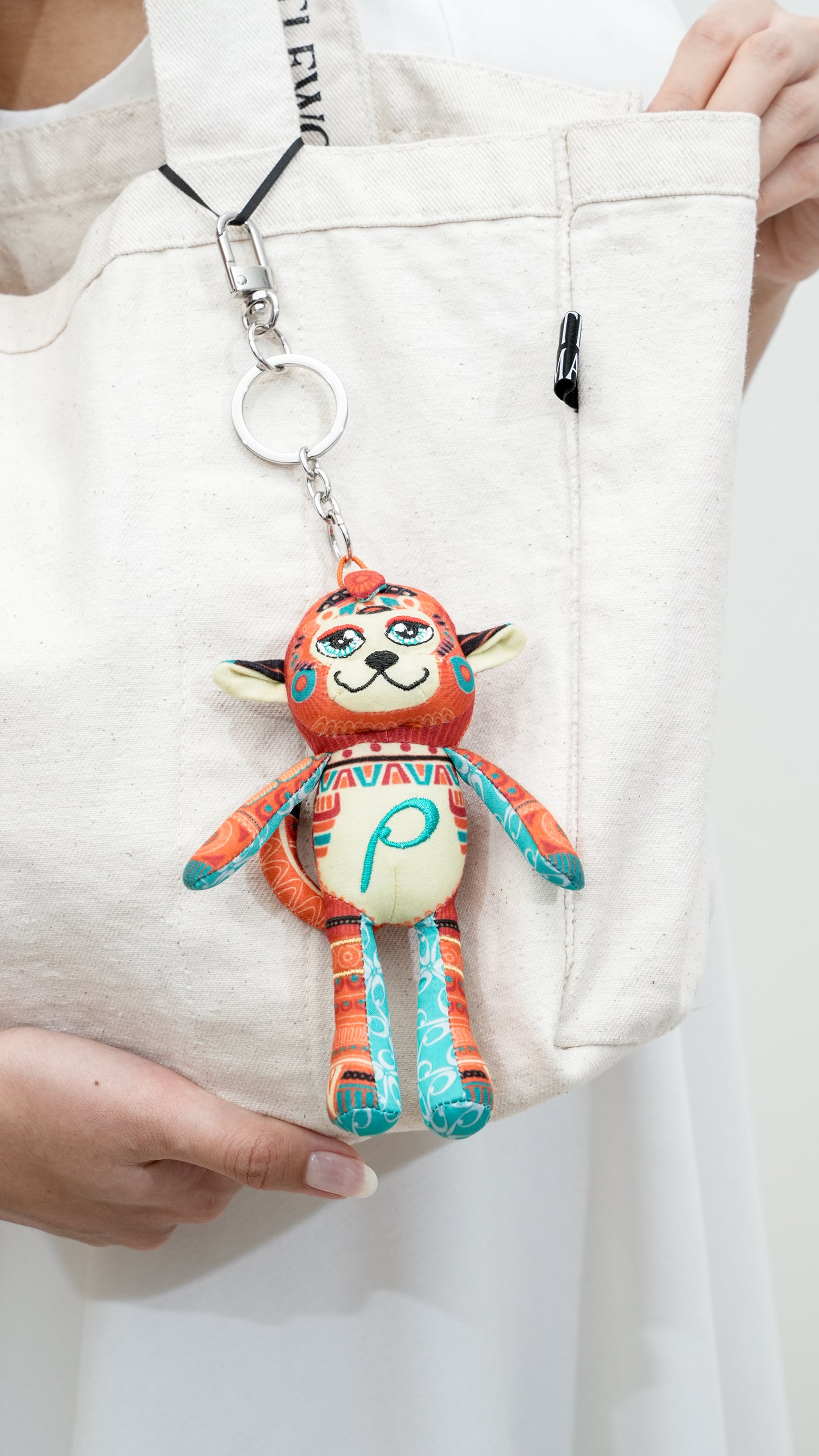 Colorful plush keychain attached to a white jacket