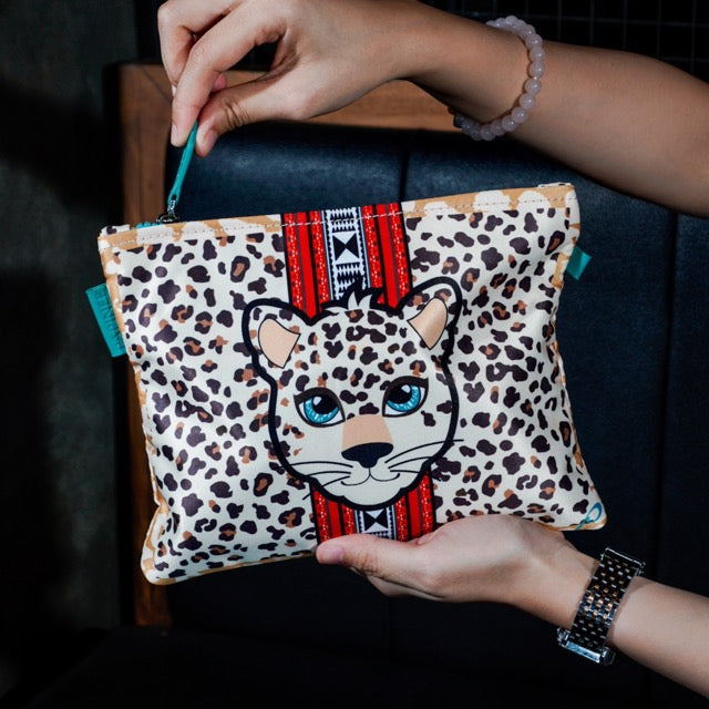 Leopard print pouch with a leopard design held by a person