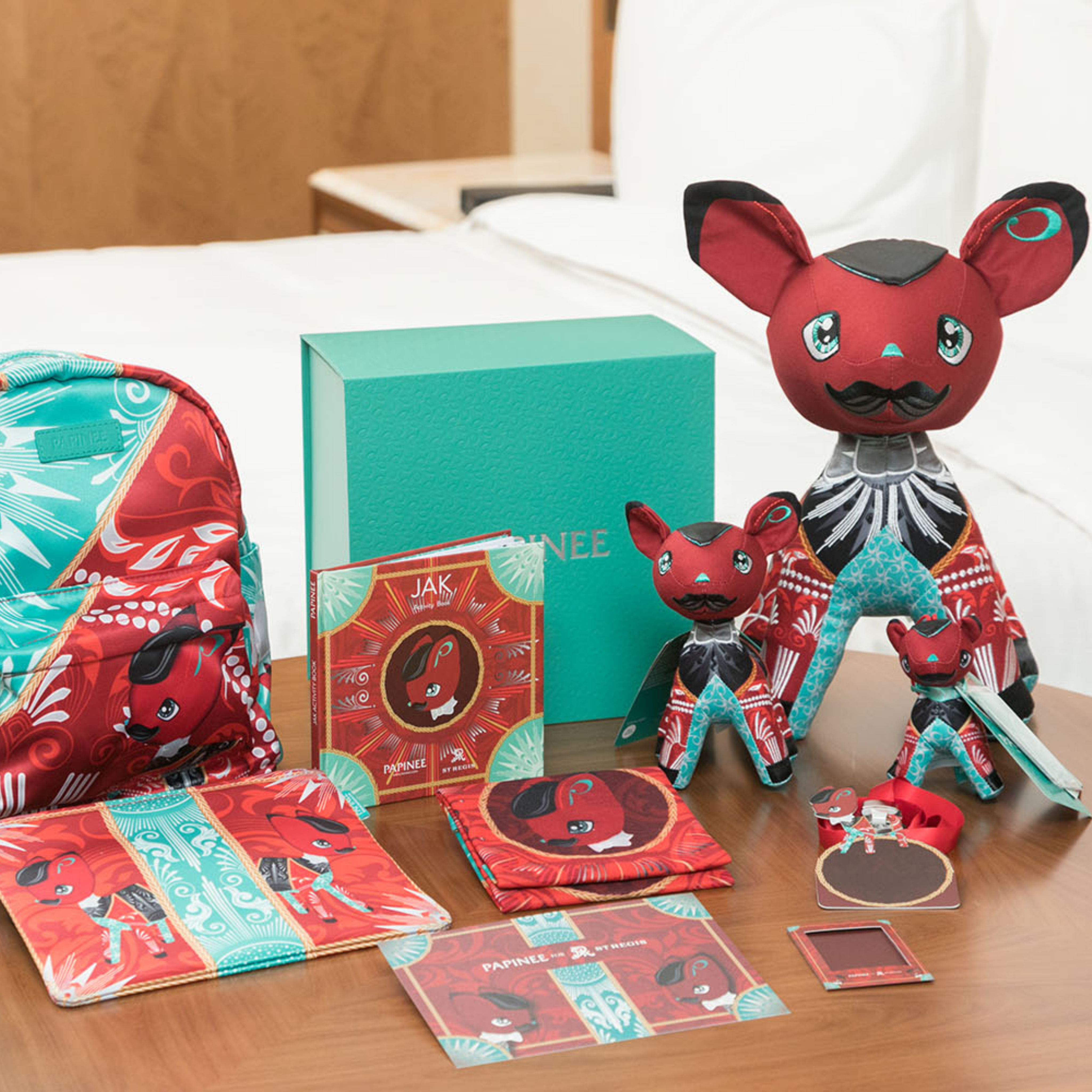 Collection of red and black plush toys with accessories on a wooden surface.