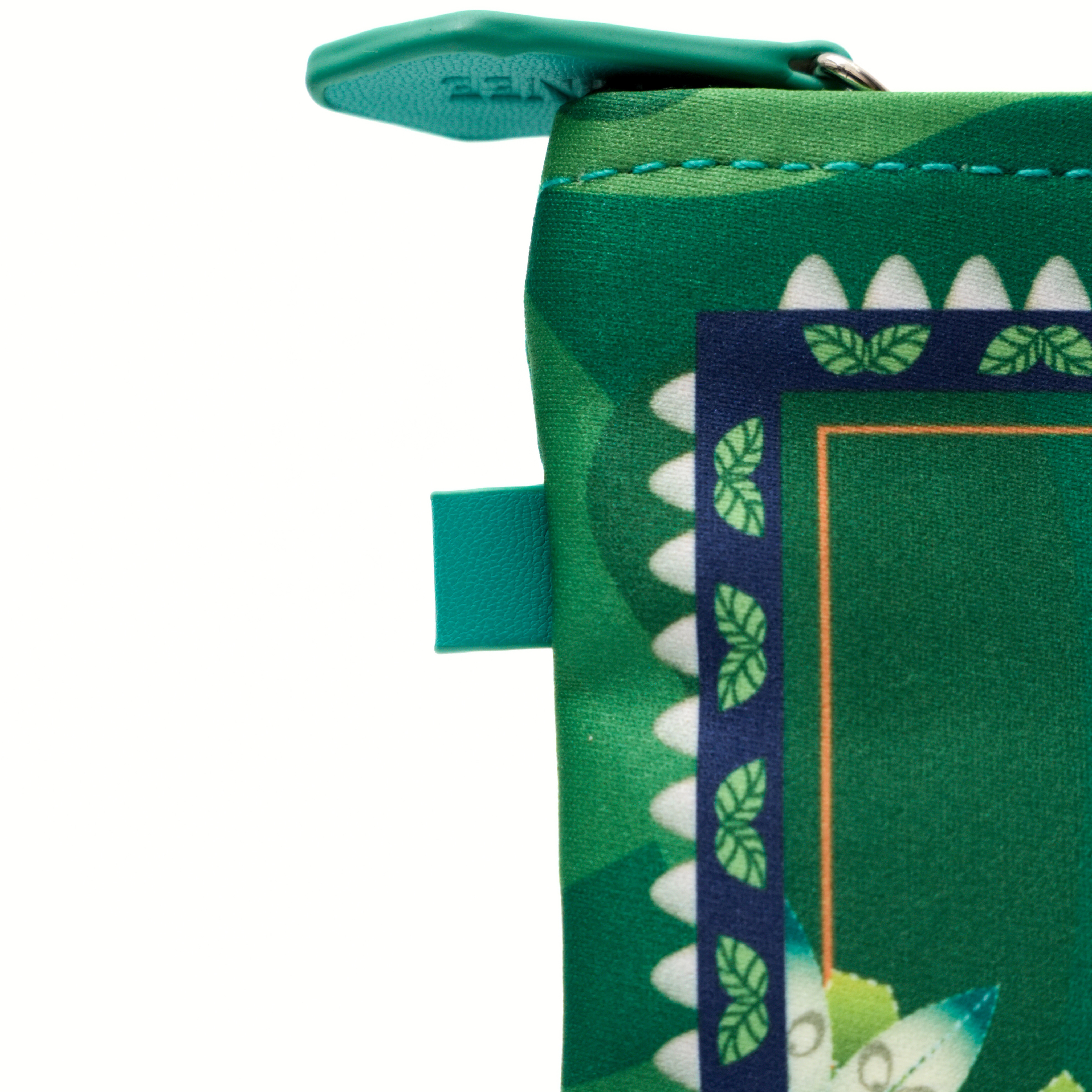 Green fabric with shark tooth pattern and zipper on a white background